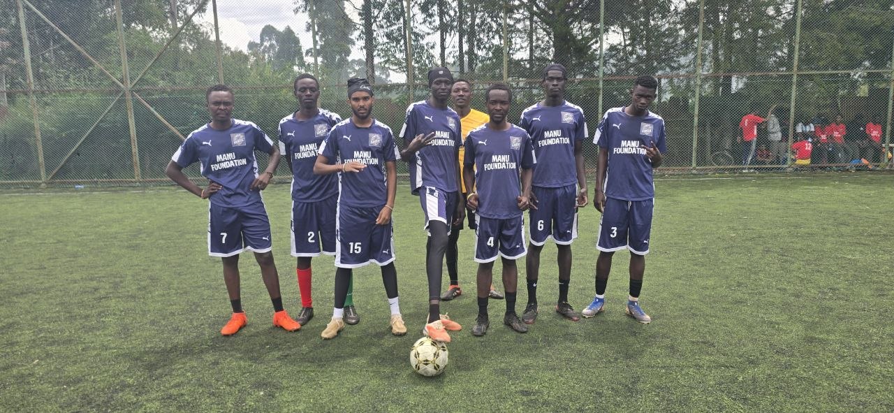 Team posing in navy blue Manu Foundation kits